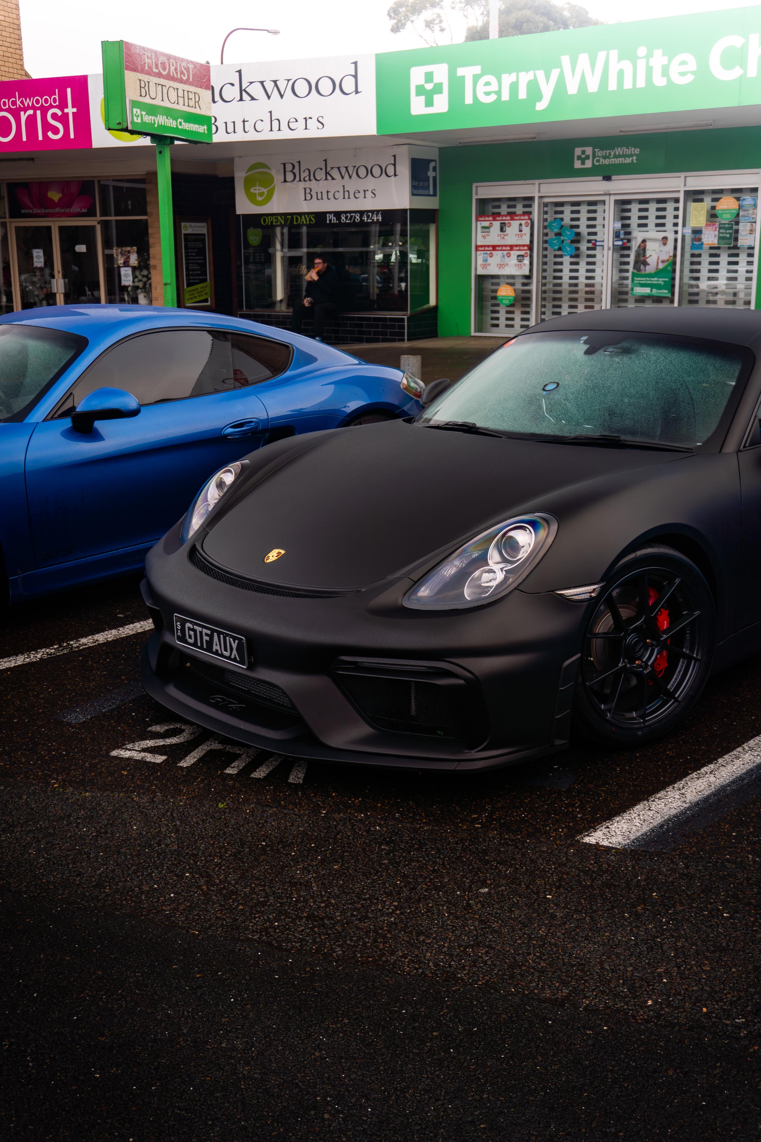 Black Porsche alongside a blue Porsche at Blackwood Cars & Coffee