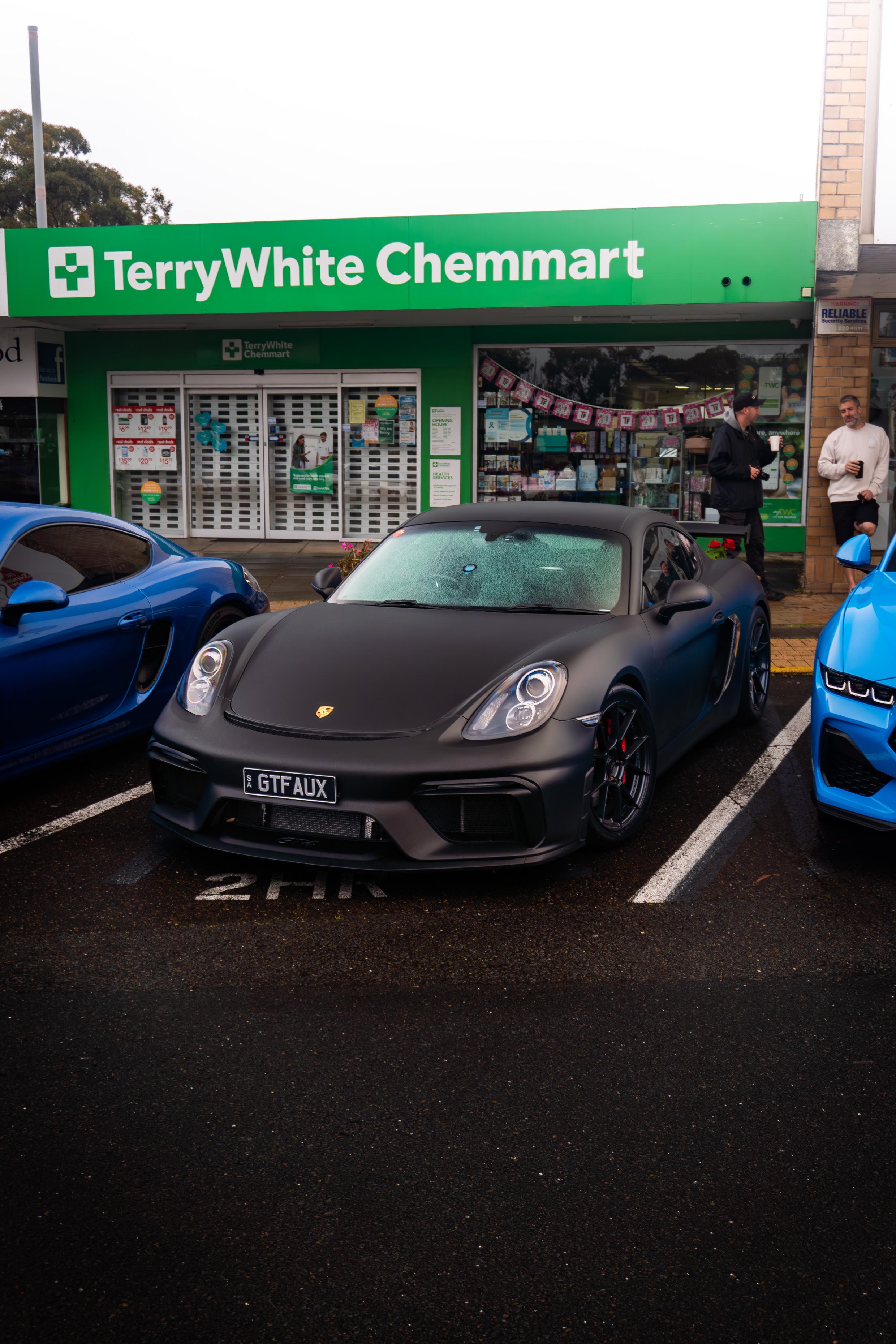 Cars gathered around a black Porsche at Blackwood Cars & Coffee
