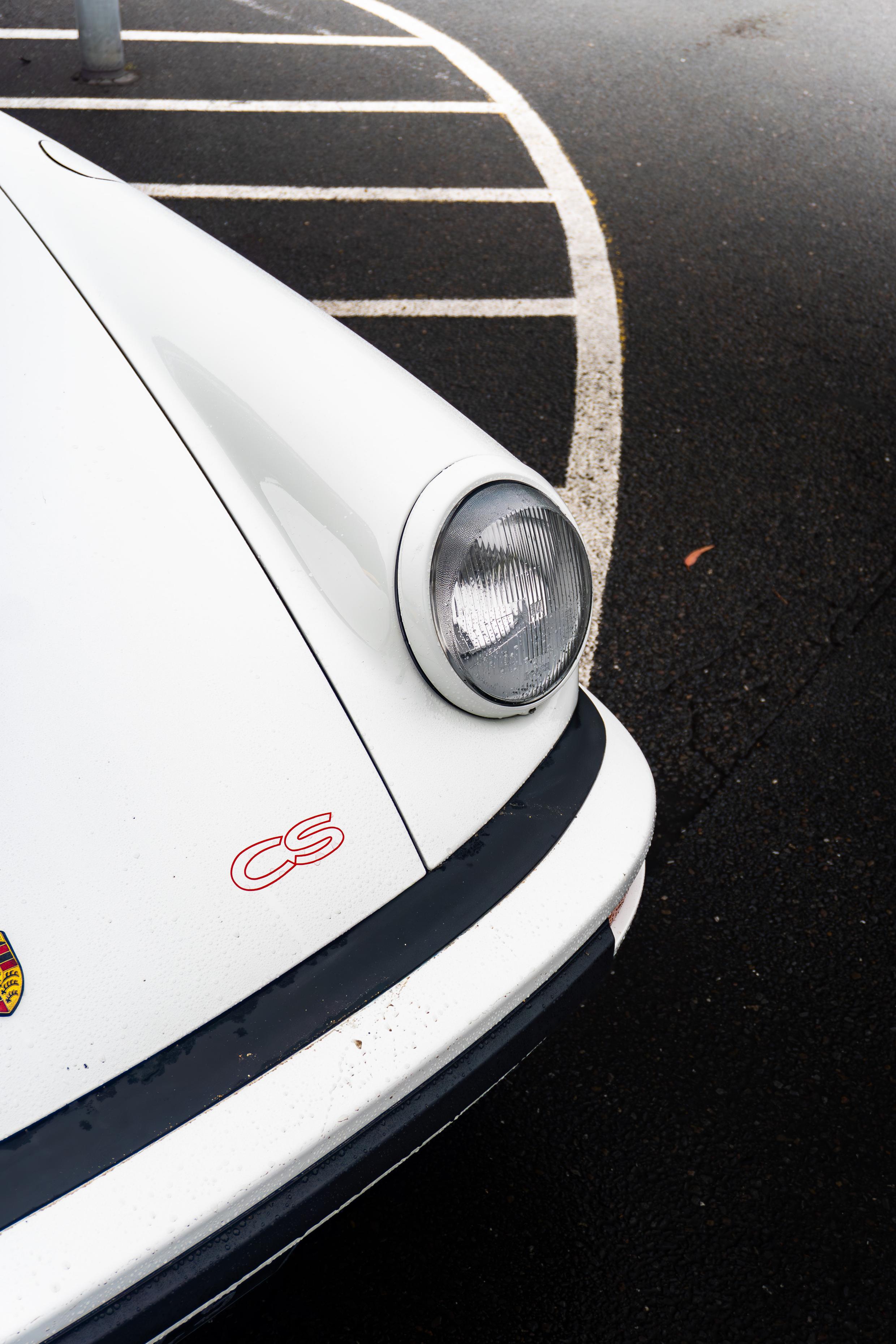 White Porsche bonnet and headlight detail with red CS lettering
