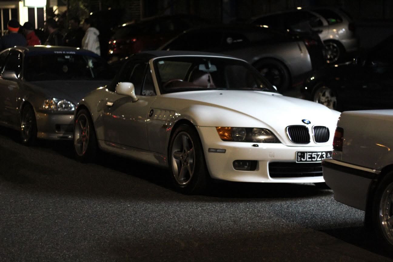 Jess’s white BMW Z3 among cars at a night meet