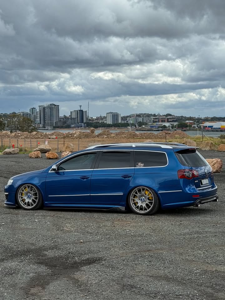 Side view of the blue Passat R36 with a city skyline in the distance