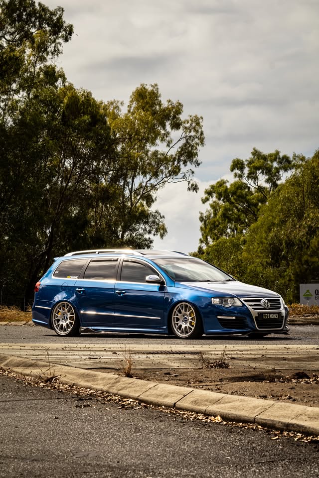 Side and front view of the blue Passat R36 parked beneath trees
